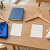 Two separate child school-day arrangements with hangers, books, blank checklists, blue cape and canvas bag