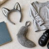 Soft grey animal ears, a fabric tail, a plain book and school shoes arranged for a Book Week costume idea