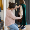Parent checking the fit of a child's generic green Book Week costume at home