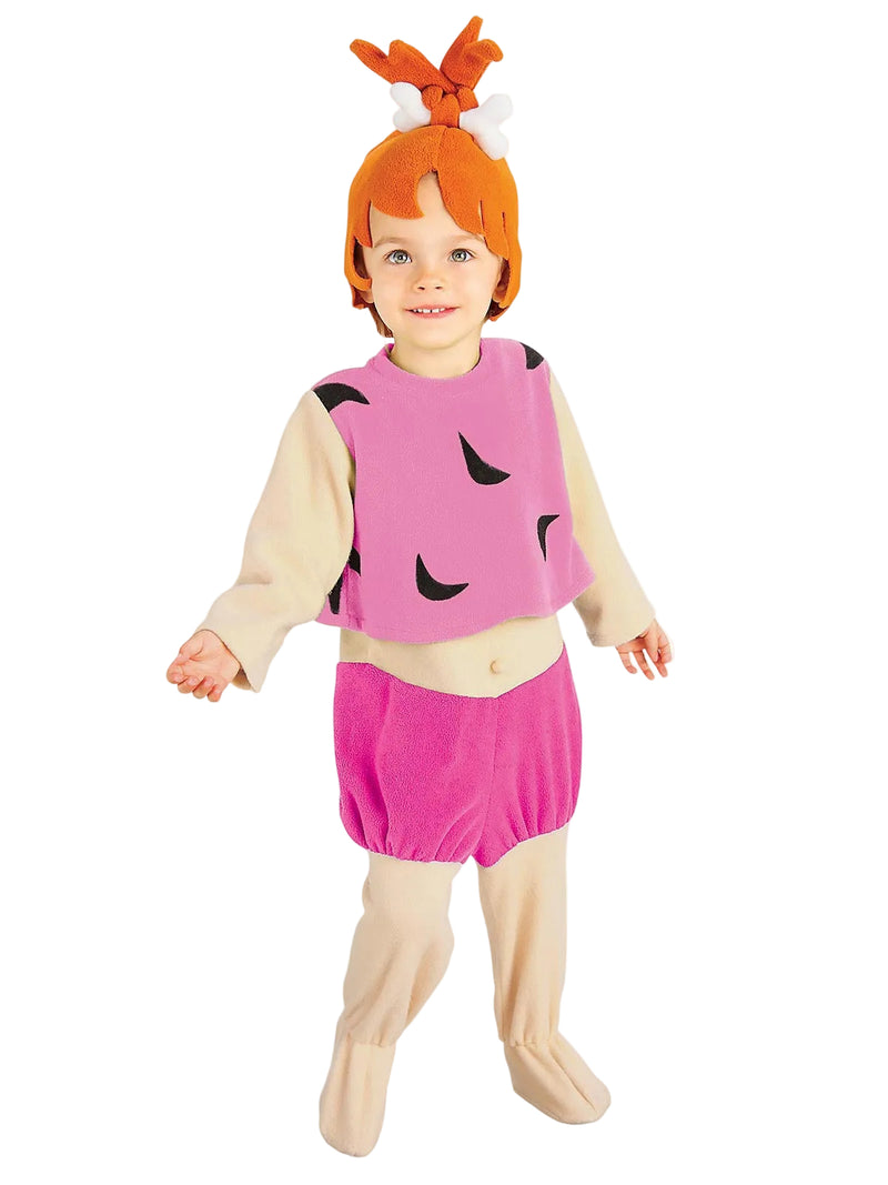 Child wearing pink Pebbles Flintstone jumpsuit costume with orange top-knot wig and bone