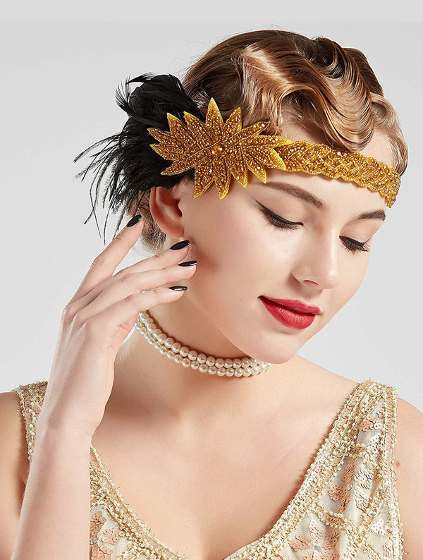 Womens 1920s flapper headband with gold beaded band, rhinestone starburst, and black feather plume