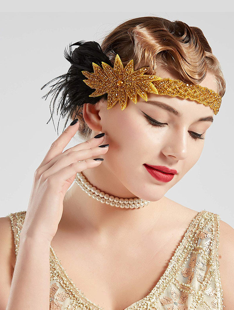 Womens 1920s flapper headband with gold beaded band, rhinestone starburst, and black feather plume