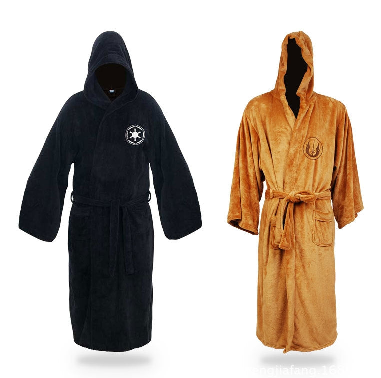Child wearing full-length brown hooded robe with embroidered order symbol on chest