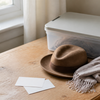 A small storage box, blank cards and simple costume pieces on a home table